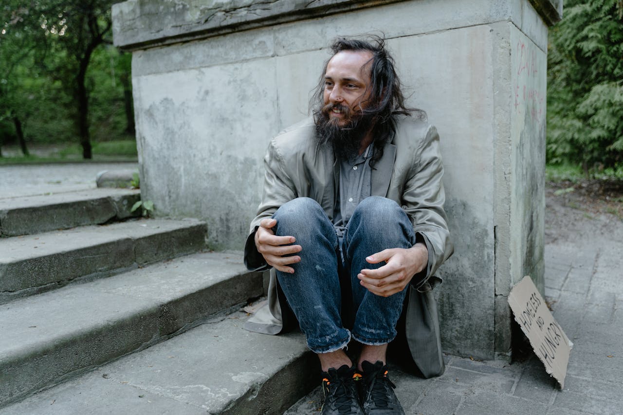 Man in Gray Coat Sitting on Concrete Stairs